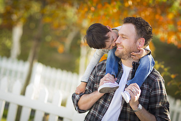 Image showing Mixed Race Boy Riding Piggyback on Shoulders of Caucasian Father