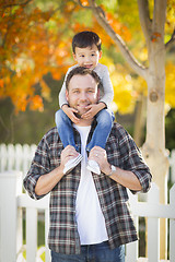 Image showing Mixed Race Boy Riding Piggyback on Shoulders of Caucasian Father