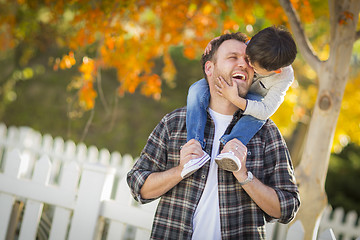 Image showing Mixed Race Boy Riding Piggyback on Shoulders of Caucasian Father