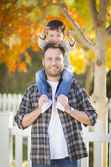 Image showing Mixed Race Boy Riding Piggyback on Shoulders of Caucasian Father