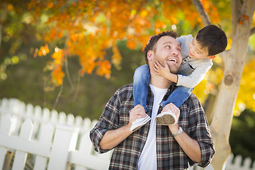 Image showing Mixed Race Boy Riding Piggyback on Shoulders of Caucasian Father