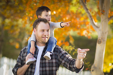 Image showing Mixed Race Boy Riding Piggyback on Shoulders of Caucasian Father