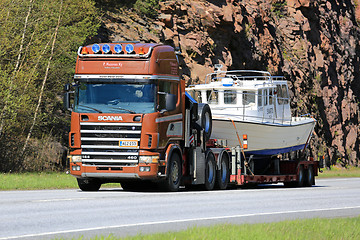 Image showing Scania 144 Hauls a Recreational Boat along Highway