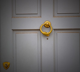 Image showing handle in london antique brown door  rusty  brass nail and light