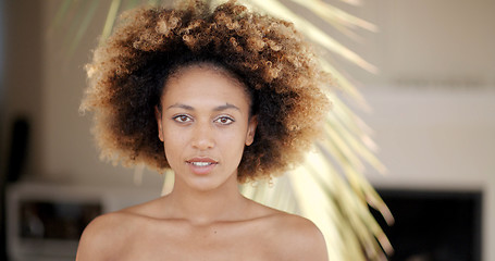 Image showing Young Woman Against Palm Tree Branch