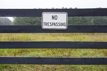 Image showing No trespassing sign against backdrop of farmland 