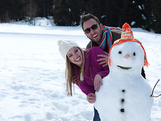 Image showing portrait of happy young couple with snowman