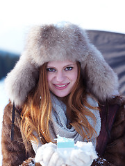 Image showing portrait of  girl with gift at winter scene and snow in backgron