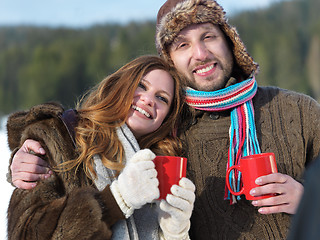 Image showing happy young couple drink warm tea at winter