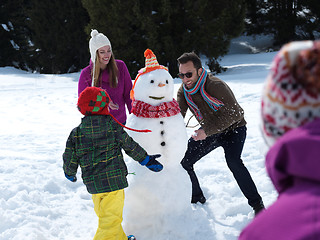 Image showing happy family making snowman