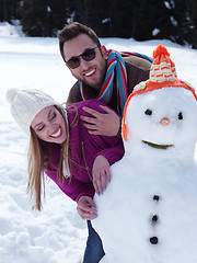 Image showing portrait of happy young couple with snowman