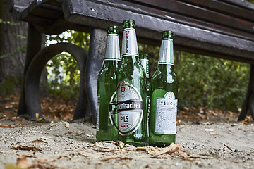 Image showing Beer bottles on benches in park