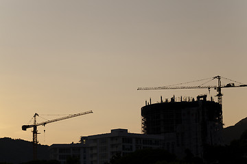 Image showing construction cranes at sunset  