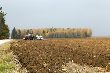 Image showing plowed field  by a tractor 