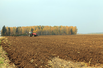 Image showing plowed field  by a tractor 