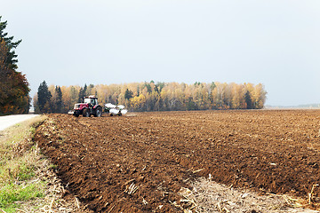 Image showing plowed field  by a tractor 