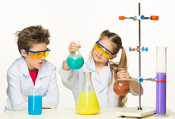 Image showing Two cute children at chemistry lesson making experiments