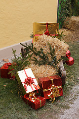 Image showing Christmas packages with straw and pine branches on a sled