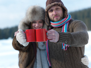 Image showing happy young couple drink warm tea at winter