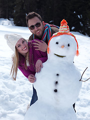 Image showing portrait of happy young couple with snowman