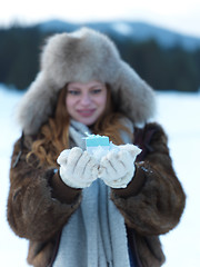 Image showing portrait of  girl with gift at winter scene and snow in backgron