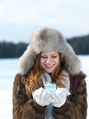 Image showing portrait of  girl with gift at winter scene and snow in backgron