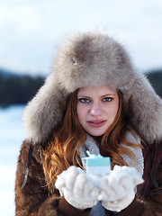 Image showing portrait of  girl with gift at winter scene and snow in backgron