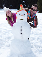 Image showing portrait of happy young couple with snowman