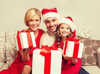 Image showing smiling family giving many gift boxes