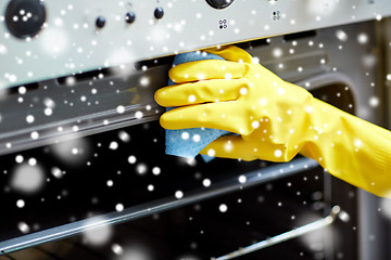 Image showing close up of woman cleaning oven at home kitchen