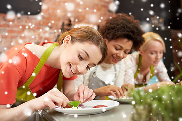 Image showing happy women cooking and decorating dishes