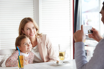 Image showing happy family picturing by smartphone at restaurant