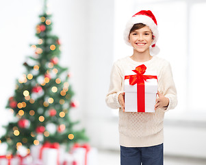 Image showing smiling happy boy in santa hat with gift box