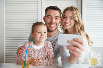 Image showing happy family taking selfie at restaurant