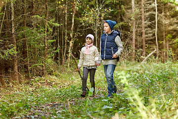 Image showing two happy kids walking along forest path