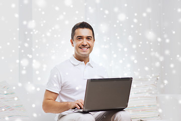 Image showing happy man working with laptop computer at home