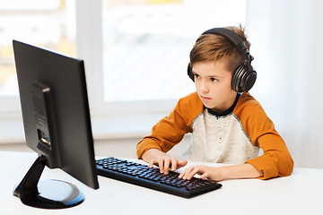 Image showing boy with computer and headphones at home