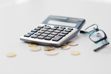 Image showing calculator, eyeglasses and coins on office table