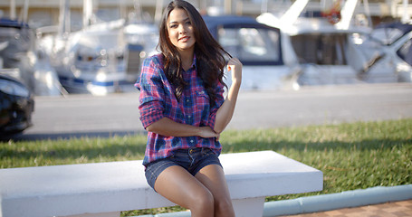 Image showing Young Woman Sitting On Bench In Harbor