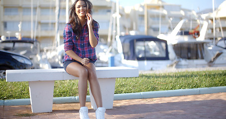 Image showing Young Woman Sitting On Bench In Harbor