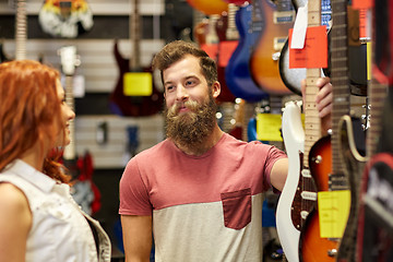 Image showing couple of musicians with guitar at music store