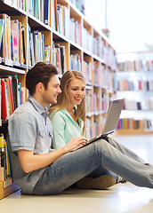 Image showing happy students with laptop in library