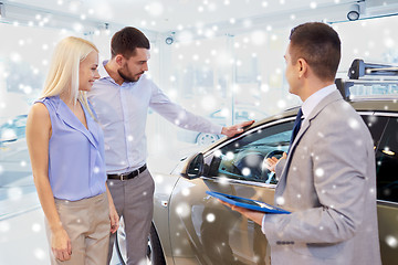 Image showing happy couple with car dealer in auto show or salon