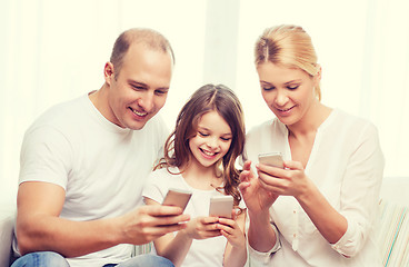 Image showing parents and little girl with smartphones at home