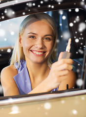 Image showing happy woman getting car key in auto show or salon