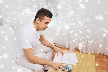 Image showing man with papers and calculator at home