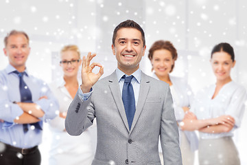 Image showing happy businessman in suit showing ok hand sign