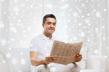 Image showing happy man reading newspaper at home