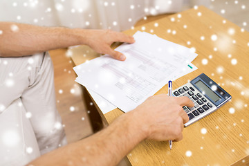 Image showing close up of man with papers and calculator at home