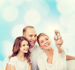 Image showing happy family with camera at home